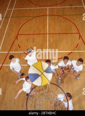 Jungen, die Basketball in der Schule Fitness-Studio, Surrey, England, Großbritannien Stockfoto