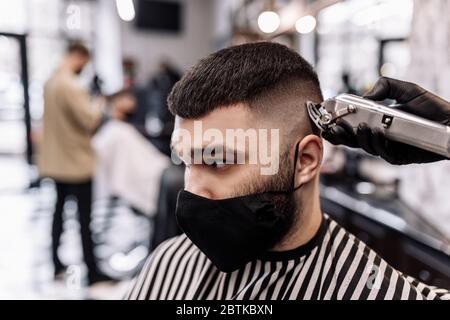 Haarschnitt in Quarantäne. Haarschnitt in Masken aus dem Virus. Haare und Gesundheit zu pflegen. Stockfoto