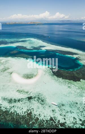 Luftaufnahme der Insel Taka Makassar im Komodo Nationalpark, Indonesien. Leeres Paradies kleine weiße Sandinsel auf Korallenriff. Stockfoto