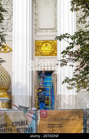 Moskau, Russland - 09. Oktober 2018: Rekonstruktion der Ausstellung der Leistungen der nationalen Wirtschaft-VDNKh.Arbeiter reparieren die Fassade und reinigen das lett Stockfoto