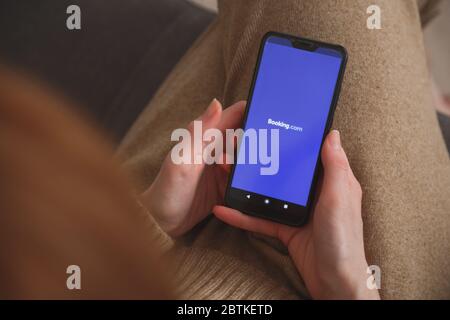 Minsk-Weißrussland: 27. Mai 2020: Nahaufnahme auf Smartphone mit Buchungslogo in Frauenhänden. Konzept der sozialen Medien. Stockfoto