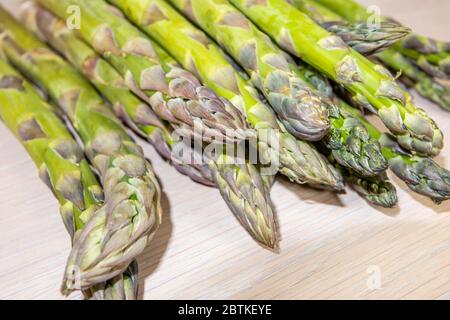 Nahaufnahme eines Bündels von geschnittenen frischen rohen Spargeln (Spargel officinalis), die im Frühjahr auf einer Tischplatte liegen (Speere und Spitzen) Stockfoto