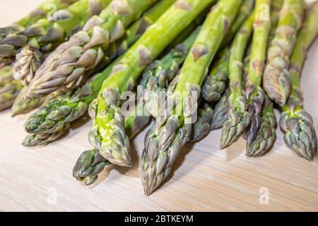 Nahaufnahme eines Bündels von geschnittenen frischen rohen Spargeln (Spargel officinalis), die im Frühjahr auf einer Tischplatte liegen (Speere und Spitzen) Stockfoto