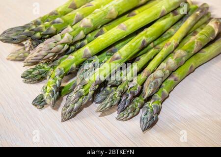 Nahaufnahme eines Bündels von geschnittenen frischen rohen Spargeln (Spargel officinalis), die im Frühjahr auf einer Tischplatte liegen (Speere und Spitzen) Stockfoto