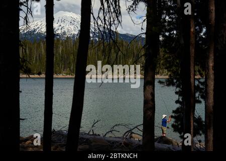 Bend, Oregon, USA. Mai 2020. Ein einsamer Angler enoys einige friedliche Angeln auf Elk Lake als Mount Bachelor steht hoch im Hintergrund. Der Tag nach dem Memorial Day bietet etwas Ruhe im Freien, da die meisten nach Hause zurückgekehrt sind. Quelle: Tobias Nolan/ZUMA Wire/Alamy Live News Stockfoto