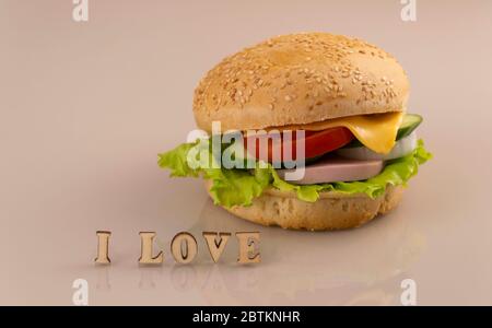 Herstellung von Sandwiches zum Frühstück. Leckere Burger auf einer Glasfläche mit Reflexion. Konzept der Herstellung von Fast Food. Stockfoto