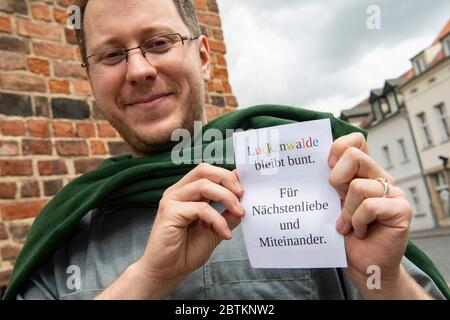 Luckenwalde, Deutschland. Mai 2020. Jonathan Steinker, Pfarrer der evangelischen Pfarrei Luckenwalde (Brandenburg), hält einen Flyer in der Hand. Er und sein Kollege Pastor Daser warten gespannt auf die Sitzung des gemeinderates am Mittwoch. Dann wird entschieden, wann und in welcher Form öffentliche Dienstleistungen wieder stattfinden können. Quelle: Paul Zinken/dpa-Zentralbild/ZB/dpa/Alamy Live News Stockfoto