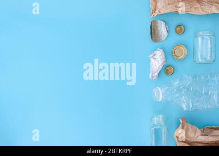 Recycelbarer verschiedener Müll bestehend aus Papier, Glas, Metall, Kunststoff auf blauem Hintergrund. Abfalltrennungskonzept. Flatlay, Kopierplatz. Stockfoto