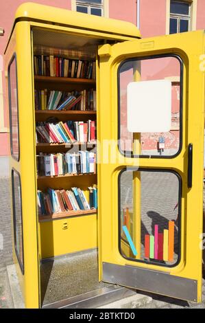 21. Mai 2020, Sachsen-Anhalt, Wörlitz: In einer alten Telefonzelle stehen Bücher auf einem Regal, die man kostenlos mitnehmen kann. Mit der Aufschrift "befreite Bücher" gehört die stillgesetzte Telefonzelle zur Antiquariatsbuchhandlung "Häuptlings Haus" in Wörlitz. Auf einem Schild an der Tür werden Interessenten begrüßt und gebeten, die Bücher gerade zu stellen. Bücher, die mitgebracht werden, können sortiert oder in der Antiquariatsbuchhandlung abgegeben werden. Foto: Waltraud Grubitzsch/dpa-Zentralbild/ZB Stockfoto