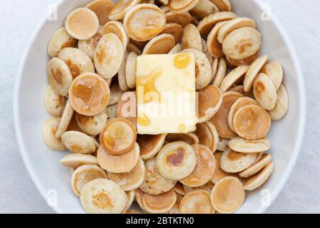 Hausgemachte Mini-Cereal-Pfannkuchen mit Butter und Ahornsirup Stockfoto