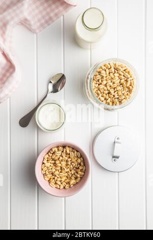 Mit Honig und Milch überzogene, gepuffte Weizensorte. Frühstück mit Cerealien. Draufsicht. Stockfoto