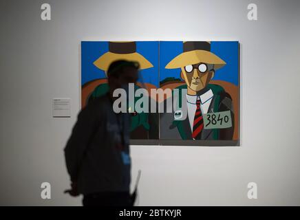 Malaga, Spanien. Mai 2020. Ein Mitarbeiter, der eine Gesichtsmaske und einen Schild als Vorsichtsmaßnahme trägt, geht während der Ausstellung an einem Gemälde vorbei. „From Miro to Barcelo“ eine Ausstellung im Museum Centre Pompidou nach der Wiedereröffnung einiger wichtiger Museen, die Sicherheitsmaßnahmen wie Gesichtsmasken garantiert, Desinfektionsmittel und Temperaturscans an den Museumseingängen. Quelle: SOPA Images Limited/Alamy Live News Stockfoto