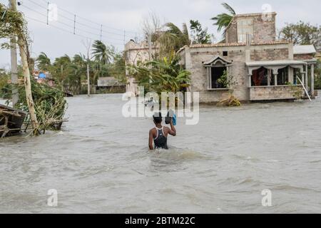 Ein Dorfbewohner geht Wasser in ihrem Dorf durch die Flut von durchbrochenen Böschungen überschwemmt, in der Folge des Zyklons Amphan. Amphan landet am 20. Mai auf Westbengalen in der Nähe der Sundarbans zwischen Digha und Hatiya, wobei Windböen entlang der Küstengebiete bei 150ñ160 km/h gemessen wurden. Der Wirbelsturm Amphan, einer der stärksten Stürme in jüngster Zeit, die durch die Bucht von Bengalen churnen und mehr als 80 Menschen töteten und den gesamten Staat am Boden ließen. Quelle: SOPA Images Limited/Alamy Live News Stockfoto