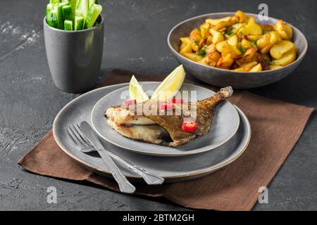 Gebratene Seebrassen mit Gewürzen und gerösteten Kartoffelspalten Stockfoto