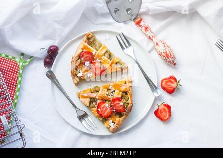 Scheiben Erdbeer und Rhabarber Pie auf weißem Teller. Draufsicht. Hausgemachte Bäckerei. Stockfoto