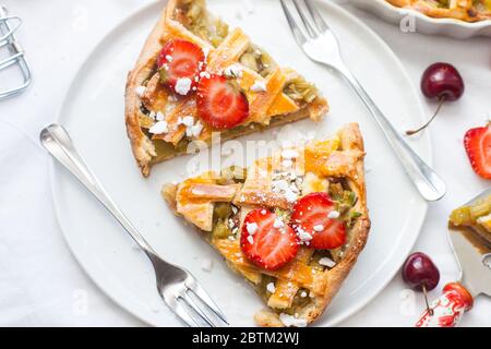 Scheiben Erdbeer und Rhabarber Pie auf weißem Teller. Draufsicht. Hausgemachte Bäckerei. Stockfoto