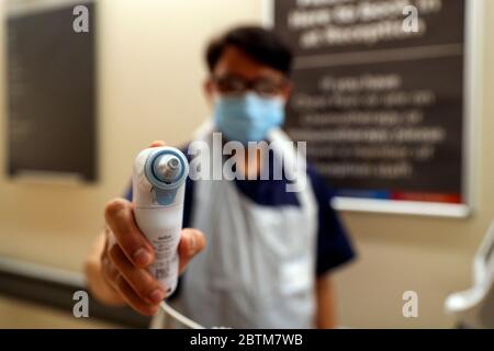 Triage Nurse Roberto Dones hält ein Thermometer, das zur Messung der Temperatur von Patienten verwendet wird, die die Notaufnahme im Wexham Park Hospital in der Nähe von Slough besuchen. Bilddatum: 22/5/2020. Stockfoto