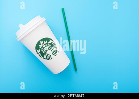 BERLIN - MAI 26: Weißer Pappbecher mit der Meerjungfrau als Starbucks Logo auf blauem Hintergrund am 26. Mai 2020 in Berlin. Stockfoto