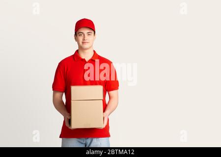 Paketversand und Hauszustellung. Kurier hält Kisten Stockfoto