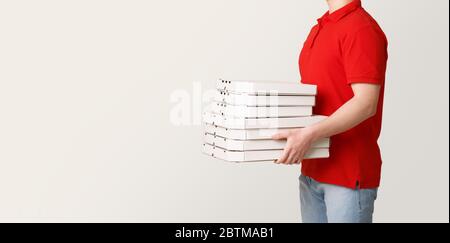 Pizza-Lieferung jederzeit möglich. Courier hält viele Kisten Pizza Stockfoto