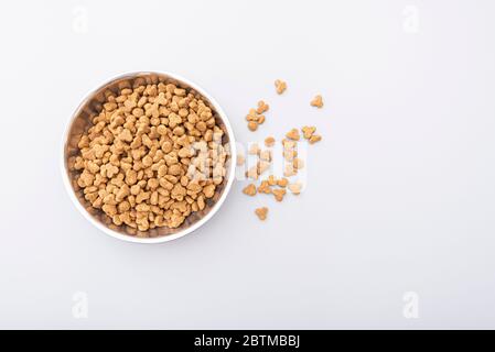 Tierfutter in Eisenschale auf grauem Hintergrund, trockenes Tierfutter für Katzen oder Hunde, Draufsicht Stockfoto