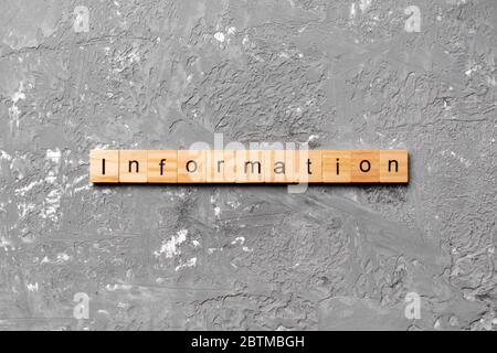 Informationswort auf Holzblock geschrieben. Informationstext auf Zementtisch für Ihr Design, Konzept. Stockfoto