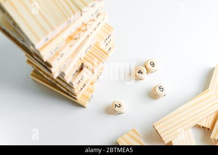 Hoher Turm aus Holzblöcken mit Nummer eins auf der Spitze gebaut. Spiel Jenga für Kinder spielen auf einem hellgrauen Hintergrund mit Kopierraum. Konzept von Stockfoto