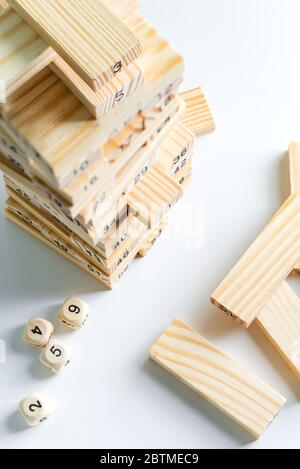Nummer eins Würfel auf der Oberseite des hölzernen Piramyd von Blöcken auf einem hellgrauen Hintergrund. Jenga Spiel für verdienen, entwickeln und Bildung. Stockfoto