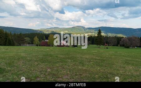 Schöne Moravskoslezske Beskiden bei Visalaje in Tschechien mit Bergwiese, wenige einsame Häuser und Hügel im Hintergrund Stockfoto