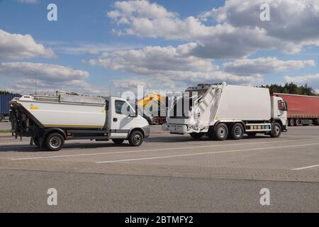 Müllwagen im Vordergrund. Fahrzeug anhalten. Eine Reihe von Lastwagen während eines Zwischenstopps, Reisen Pausen. Stockfoto