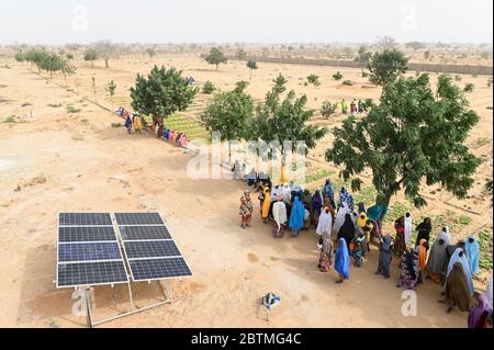 NIGER, Maradi, Dorf Dan Bako, Projekt Armutsbekämpfung und Anpassung des Klimawandels, Gemüseanbau mit Bewässerung, Wasser wird mit Solarpumpe gepumpt, Frauen am Solarpanel / Projekt Armutsbekaempfung und Anpassung an den Klimawandel, Gemüsegarten mit Bewässerung, Solar Panel für Wasserpumpe zur Bewässerung Stockfoto