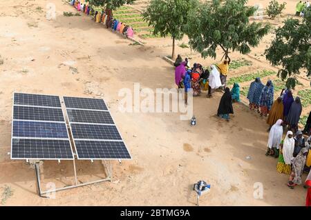 NIGER, Maradi, Dorf Dan Bako, Projekt Armutsbekämpfung und Anpassung des Klimawandels, Gemüseanbau mit Bewässerung, Wasser wird mit Solarpumpe gepumpt, Frauen am Solarpanel / Projekt Armutsbekaempfung und Anpassung an den Klimawandel, Gemüsegarten mit Bewässerung, Solar Panel für Wasserpumpe zur Bewässerung Stockfoto