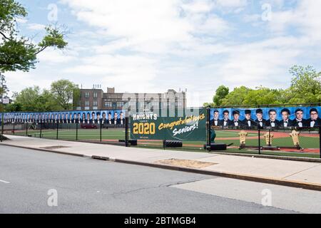 Anstelle einer Abschlussfeier hängte die High School des Heiligen Kreuzes ein Banner und Fotos der abschlussenden Senioren auf. In Flushing, Queens, New York. Stockfoto