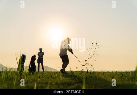 Paar in Aktion Golf zusammen spielen. Hindernisse für Golfrills in rauen Bereichen und schwierigen Bohrern. Schwierige Zeit Aufenthalt zusammen in der Familie CO Stockfoto