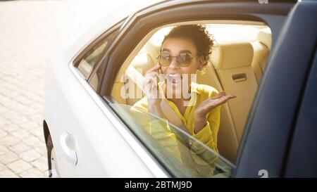 Fröhliches Mädchen Chat Am Telefon Sitzen Im Auto, Panorama Stockfoto