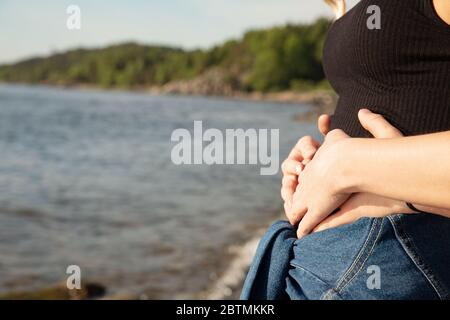 Nahaufnahme der Hände von Mann und Frau auf dem frühen schwanger Magen Stockfoto