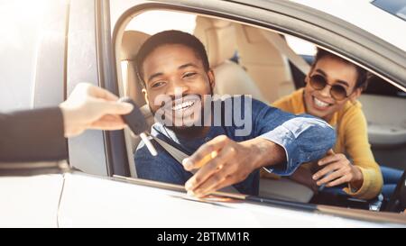 Fröhliches Paar, Das Schlüssel Vom Händler Nimmt, Der Im Auto Sitzt, Panorama Stockfoto