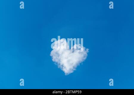 Romantische Wolke in Form eines Herzens auf einem blauen Himmel. Liebeskonzept. Stockfoto