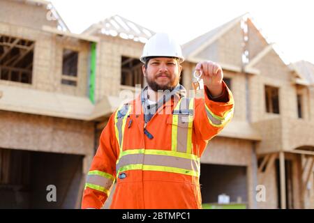 Porträt von lächelnden Ingenieur Schlüssel aus dem neuen Haus. Stockfoto