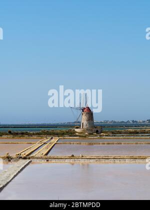 Eine alte Windmühle und Salzpfannen in sizilien Stockfoto