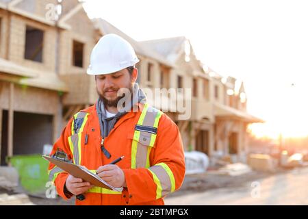 Kaukasischer Architekt Schreiben in Notizbuch auf der Baustelle. Stockfoto