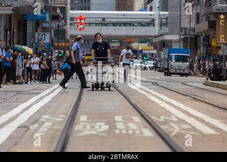 Central, Hongkong. 27. Mai 2020 Hongkong Protestiert Gegen Das Anti-Nationalhymne-Gesetz. Für einige Leben geht auch während eines Protestes weiter. Dies ist eine häufige Szene in Hongkong - Menschen schieben Trolleys durch Straßen. Kredit: David Ogg / Alamy Live News Stockfoto