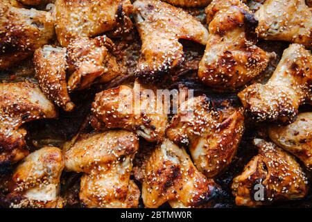 Gebackene eingelegte Hähnchenflügel. Mit Sesamsamen bestreut. Kochen Huhn mit Gewürzen im Ofen Flat Lay. Nahaufnahme Stockfoto