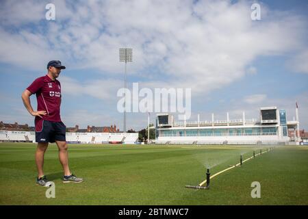 Der Chefgroundsmann Craig Harvey neigt zum Außenfeld am County Ground, der Heimat des Northamptonshire County Cricket Club, da professionelle Cricket-Spiele darauf warten, nach der Coronavirus-Pandemie wieder grünes Licht zu geben. Stockfoto