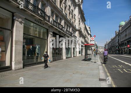 REGENT STREET LONDON, GROSSBRITANNIEN. 27 Mai 2020. Ein Fußgänger mit Schutzmaske geht an geschlossenen Geschäften in einer verlassenen Regent Street London vorbei. Alle nicht-wesentlichen Einzelhändler können in England ab dem 15. Juni wieder eröffnet werden, da die Regierung plant, die Lockdown-Maßnahmen weiter zu erleichtern. Geschäfte müssen sich an neue Richtlinien halten und die sozialen Abgrenzung Regeln auf allen Betriebsstätten befolgen, um Käufer und Arbeiter vor Covid-19 Coronavirus zu schützen.Quelle: amer Ghazzal/Alamy Live News Stockfoto