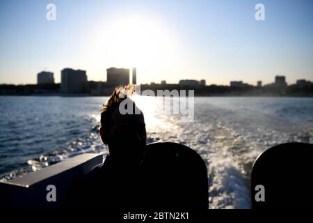 Europa, Ukraine, Odessa. Silhouette eines Mannes gegen das Licht auf einem Boot beobachten den Hafen von Odessa. Stockfoto