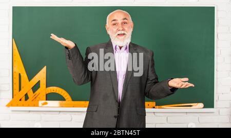 Wer kennt die Antwort. Mathematische grafische Werkzeuge. trigonometrie Unterricht im Klassenzimmer. Holen Sie sich Wissen hier. Senior Mann Lehrer verwenden mathematische Werkzeuge. Bärtigen Dozent Mann erklären Geometrie auf Tafel. Zurück zur Schule. Stockfoto
