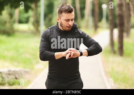 Mann, Der Läuft, Überprüft Activity Tracker Auf Der Handgelenkuhr Stockfoto