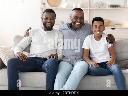 Fröhliche Männliche Familienmitglieder Posieren Kamera Zu Hause Stockfoto