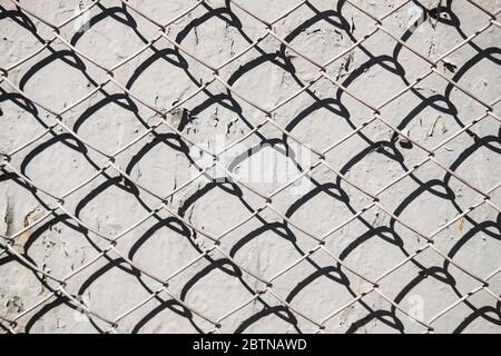 Metallgeflecht Muster auf Beton Wand Hintergrund mit Schatten. Abstrakte Textur Stockfoto